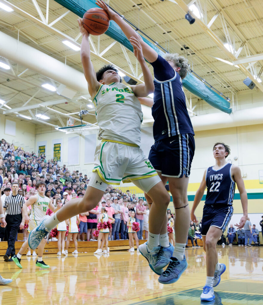 Lynden Christian’s Kaden Veldman blocks a shot by Lynden’s Jayden Navarre.