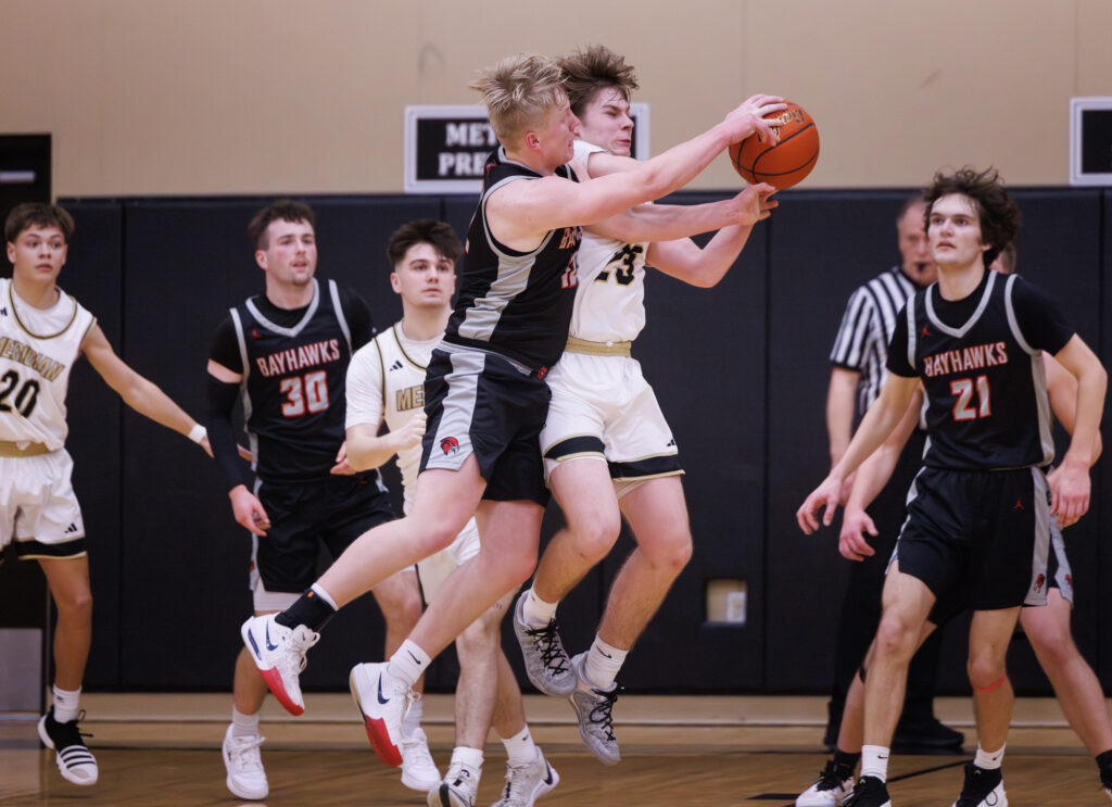 Bellingham’s Calvin Van Hofwagen slams into Meridian’s Pierce Brzozowski as they leap and reach for the ball.