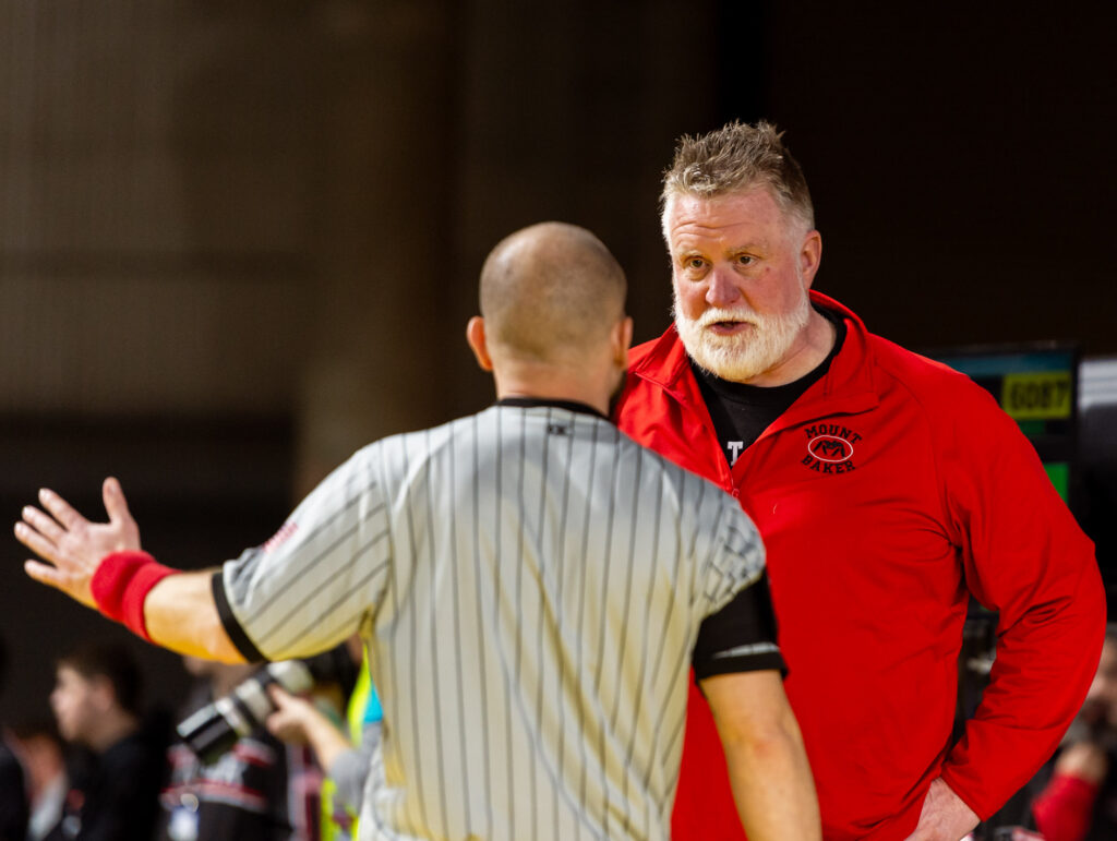 Mount Baker coach Ron Lepper discusses a call with an official.