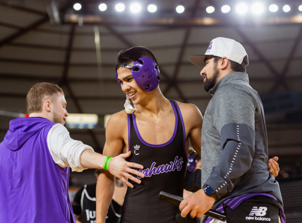 Anacortes’ Dominic Ellertson receives praise from his coaches after pinning Black Hills’ Jude Bender in a 2A boys 126-pound match.