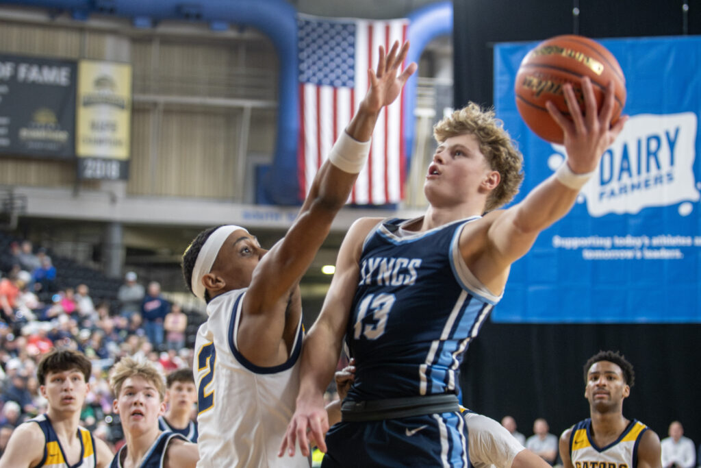 Lynden Christian senior Gannon Dykstra attacks the basket with an Annie Wright defender in his face.