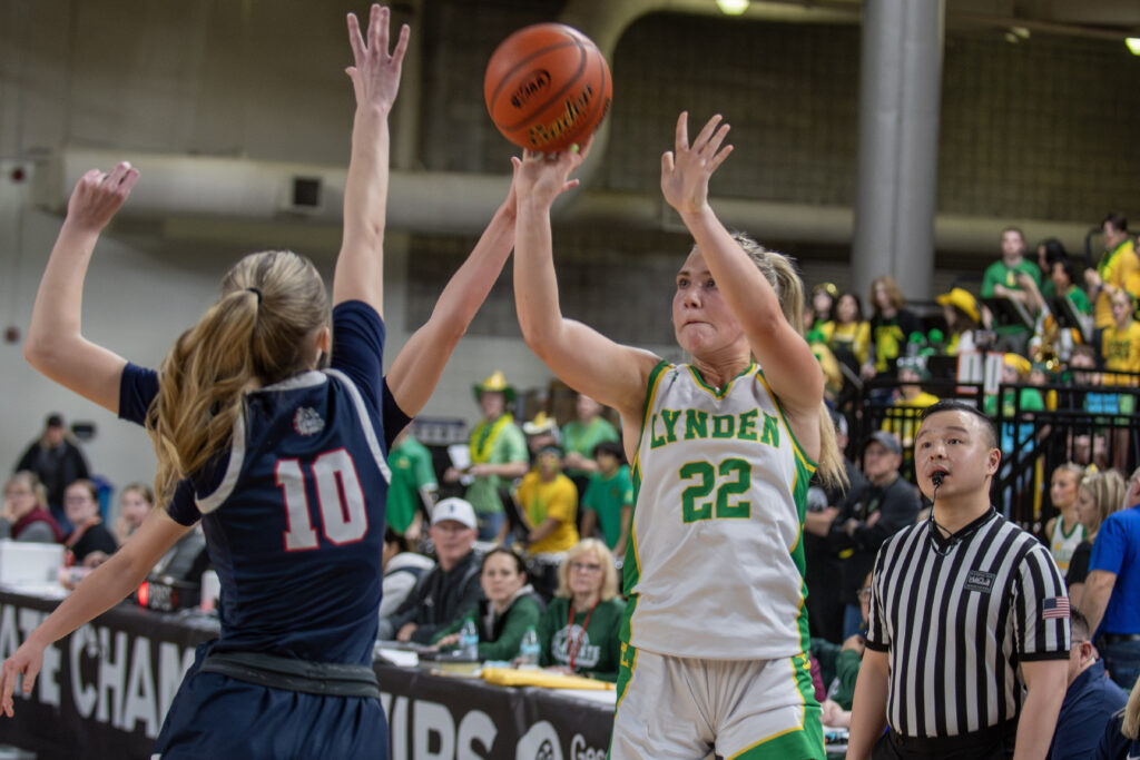 Lynden sophomore Finley Parcher shoots a 3-pointer with two Ellensburg defenders in her face.