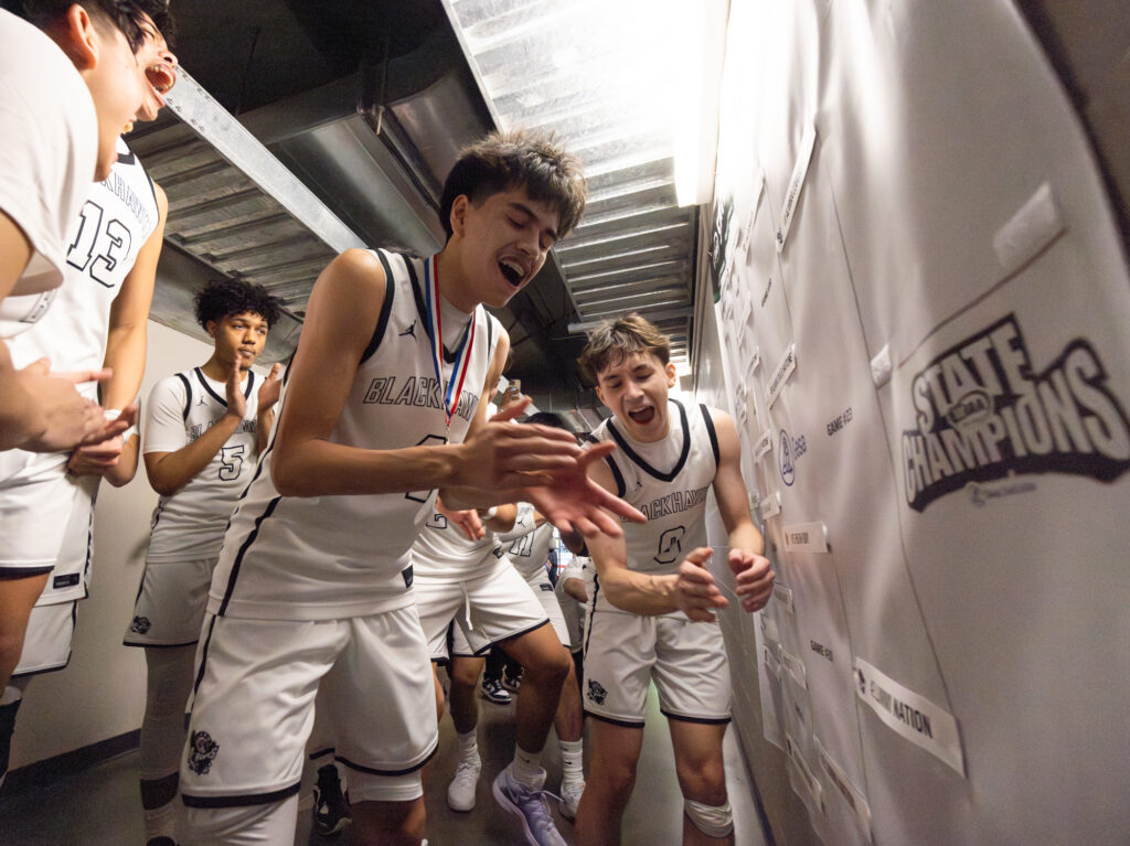 The Blackhawks celebrate after placing their team logo on the championship slot on the bracket.