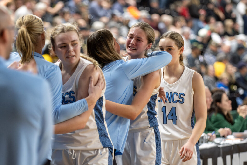 Lynden Christian senior Danya Dykstra, middle, and her teammates hug each other March 8 as they come off the court for the last time after beating Annie Wright, 50-36, to place third at the 1A state tournament at the Yakima Valley SunDome.