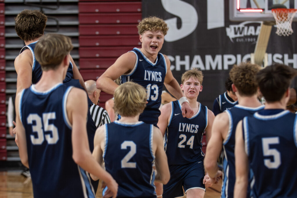 Lynden Christian senior Gannon Dykstra leaps in celebration March 7 after the Lyncs beat Royal 56-49 to secure a spot in the 1A state title game at the Yakima Valley SunDome.