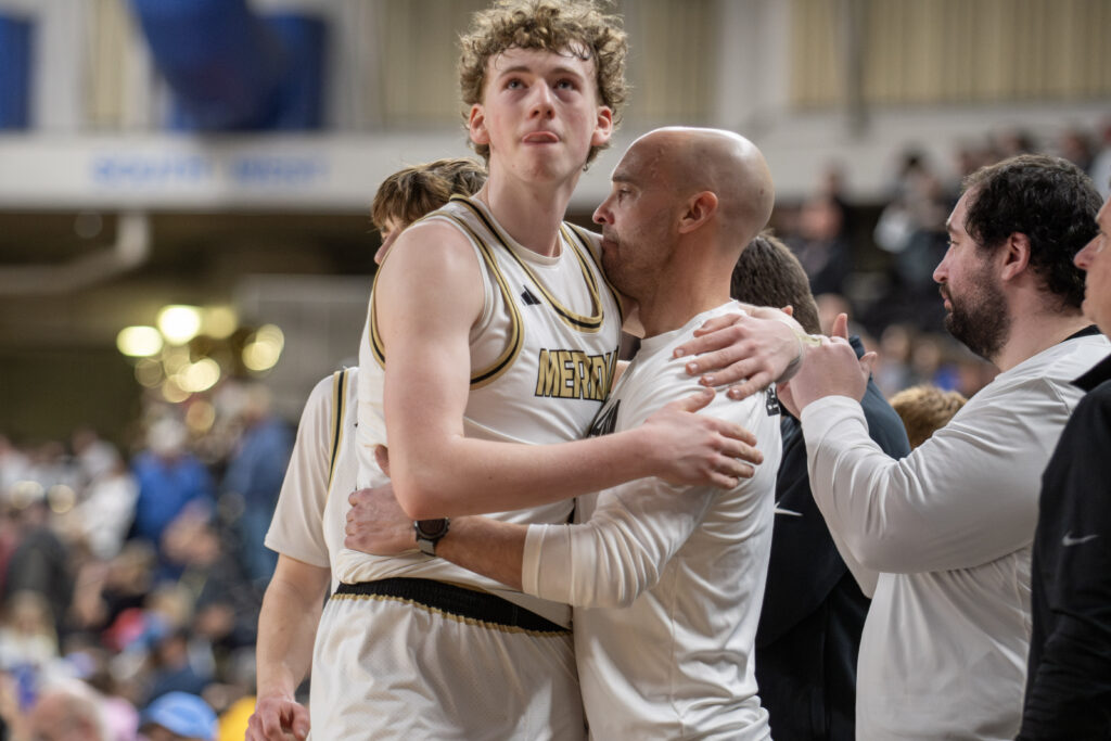 Meridian senior Talon Jenkins and coach Shane Stacy hug March 8 after the Trojans beat Chelan, 59-48, to place fourth in the 1A state tournament at the Yakima Valley SunDome.