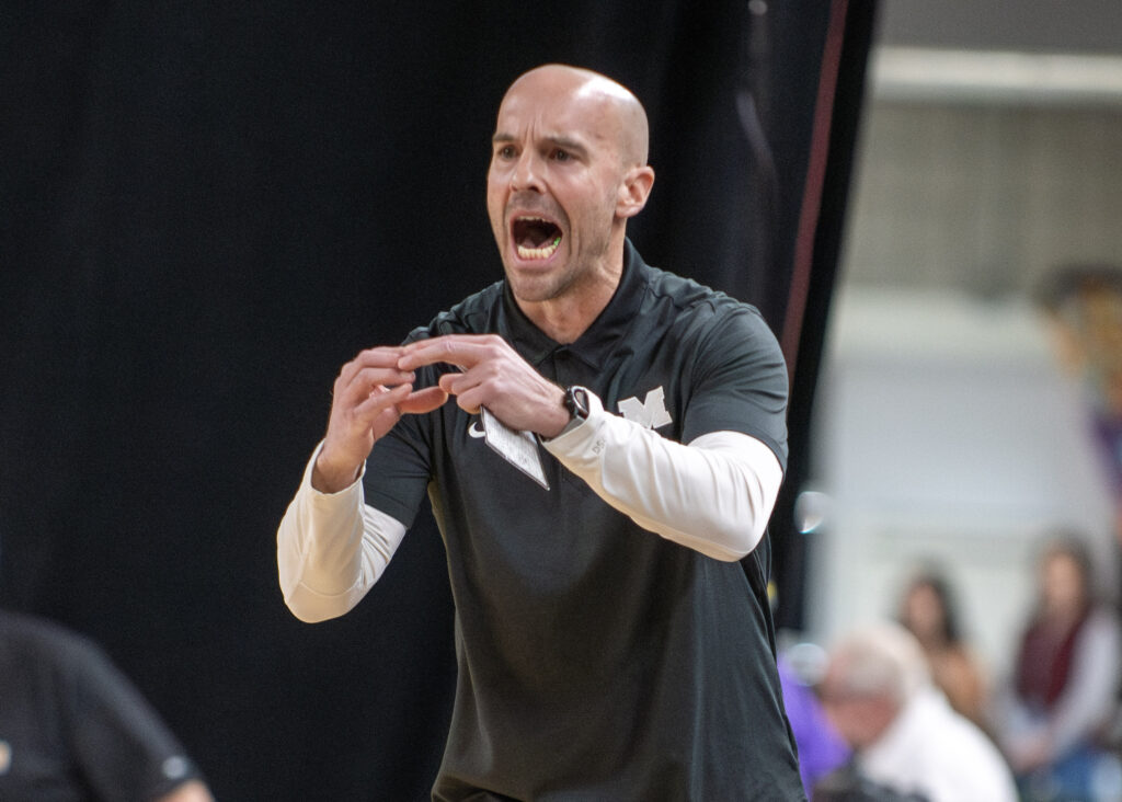 Meridian coach Shane Stacy calls out a play to his team from across the court.