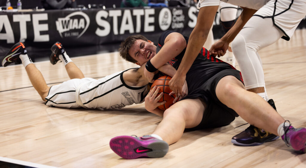 Lummi junior guard Jerome Toby (0) and Neah Bay's Seactis Woodruff fight for a loose ball.