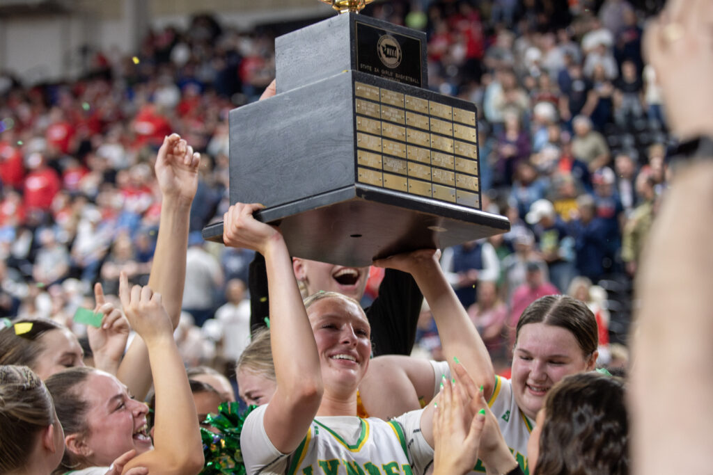 Lynden junior Rian Stephan hoists the Gold Ball trophy March 8 after the Lions defeated Ellensburg, 54-37, to win their second straight 2A state title at the Yakima Valley SunDome.