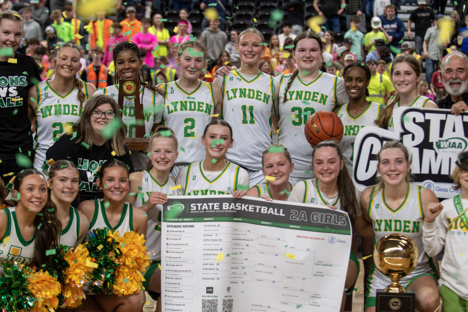 Lynden girls basketball players pose with the Gold Ball trophy after winning the 2A state title.