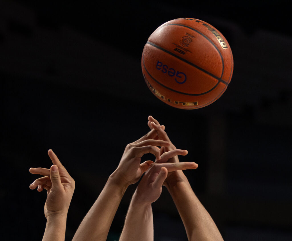 Players reach for a rebound.