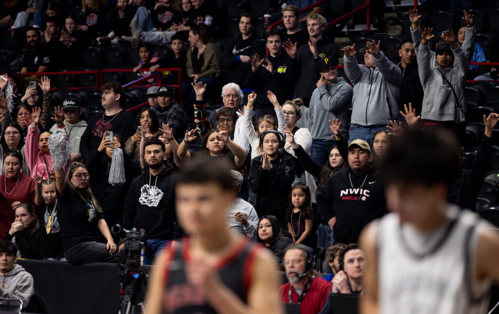 Lummi Nation fans wiggle their fingers during a late-game free throw attempt.